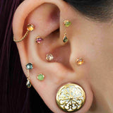 Close-up of matte peridot gem in demi bezel piercing stud