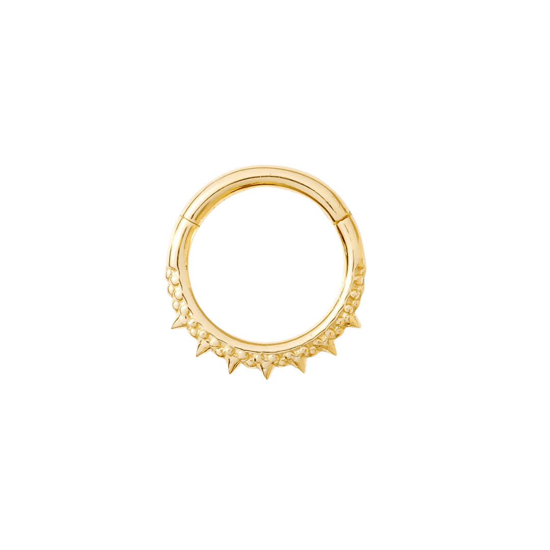 Close-up of ornate spiked Brooklyn clicker in yellow gold