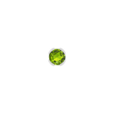Macro image of green peridot set in solid gold demi bezel