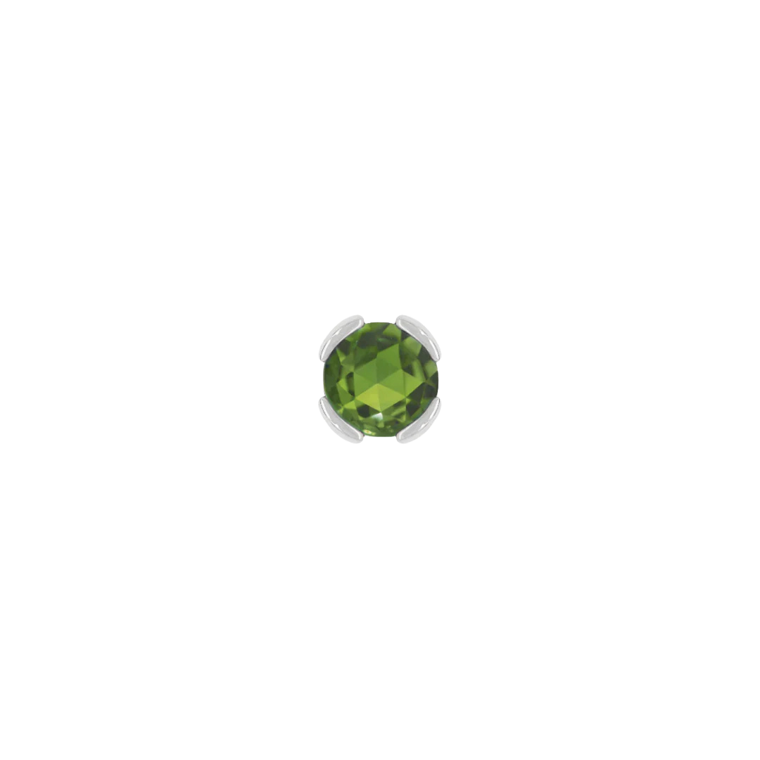 Macro shot of rose-cut green tourmaline set in solid gold bezel